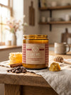 Jar of Big Bear Honey Cafe Miel candle on a wooden table with honeycomb and coffee beans.