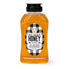 Bottle of Big Bear Honey with a checkered label on a white background