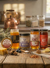 Collection of honey jars and related products on a wooden surface with a kitchen background.