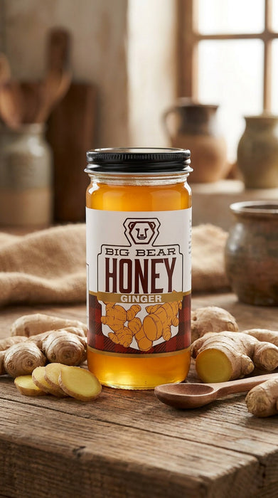 Jar of Big Bear Honey Ginger on a wooden surface with ginger roots and a wooden spoon.