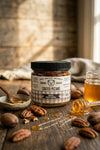 Jar of Big Bear Honey Coated Pecans on a wooden surface with honey and pecans.