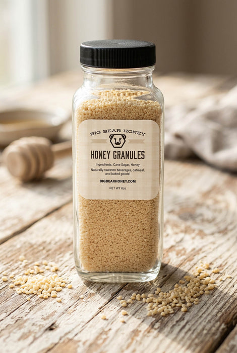 Jar of honey granules on a wooden surface with a blurred background