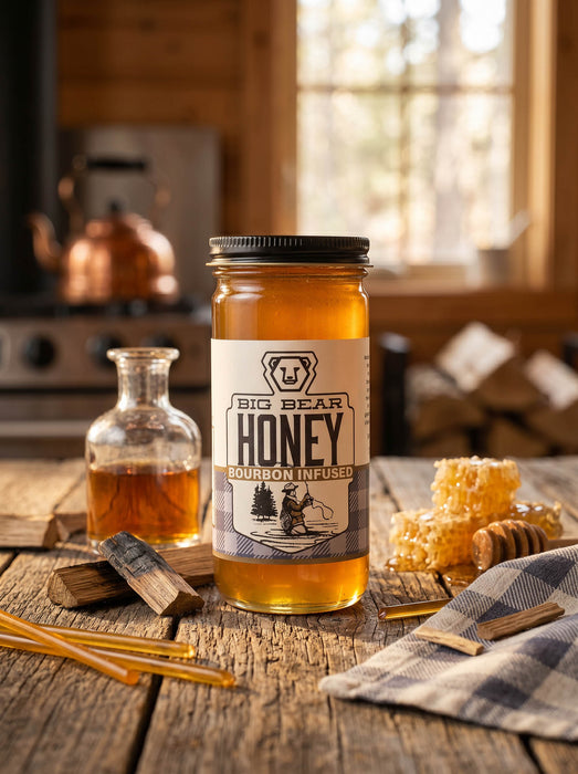 Jar of Big Bear Honey on a wooden table with honeycomb and bottle in a rustic setting