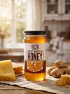 Jar of Big Bear Honey Ginger on a wooden table with honeycomb and ginger in a kitchen setting