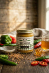 Jar of honey mustard with ingredients on a wooden surface
