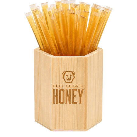 Bamboo container filled with honey sticks branded 'Big Bear Honey' on a white background.