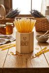 Wooden honey dipper set with honey sticks on a wooden table.