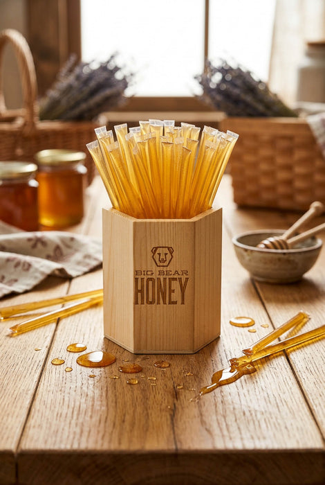 Wooden honey dipper set with honey sticks on a wooden table.