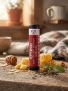Lip balm with peppermint and bear honey flavor on a wooden surface with honeycomb and flowers.