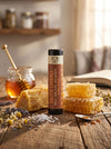 Salted Caramel lip balm with honeycomb and jar of honey on a wooden surface