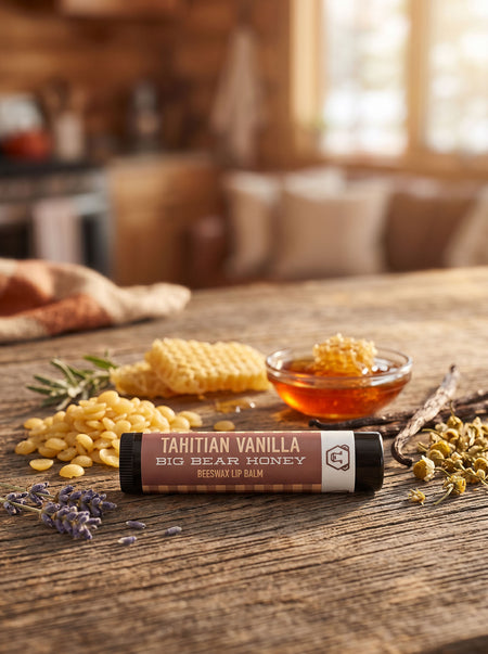 Lip balm with Tahitian Vanilla and Big Bear Honey on a wooden table with honeycomb and lavender.