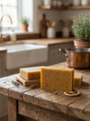 Three bars of soap on a wooden surface with a kitchen background