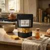 Bag of wild honey candy on a kitchen counter with honey and honeycomb.
