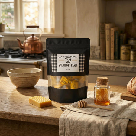 Bag of wild honey candy on a kitchen counter with honey and honeycomb.