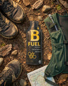 B Fuel bottle on a forest floor with hiking boots and a map