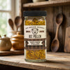 Jar of Big Bear Honey Bee Pollen on a wooden surface with kitchen utensils in the background