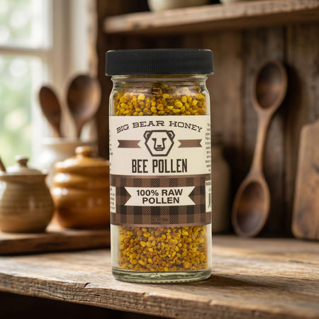 Jar of Big Bear Honey Bee Pollen on a wooden surface with kitchen utensils in the background