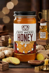 Jar of Big Bear Honey Ginger with ginger root and honey bear on a wooden table.
