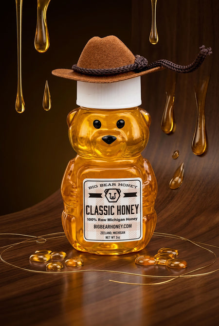 Honey bear bottle with a cowboy hat on a wooden surface with honey drizzling.
