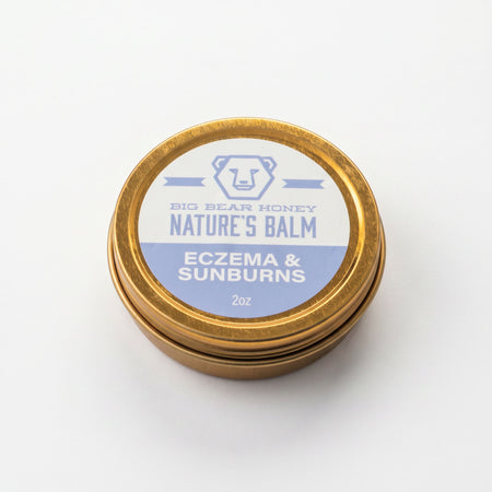 Gold tin of Big Bear Honey Nature's Balm for eczema and sunburns on a white background