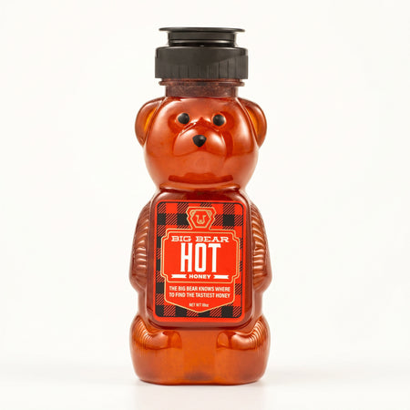 Bear-shaped hot honey jar with a red label on a white background