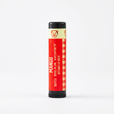 Mango lip balm tube with black cap on a white background